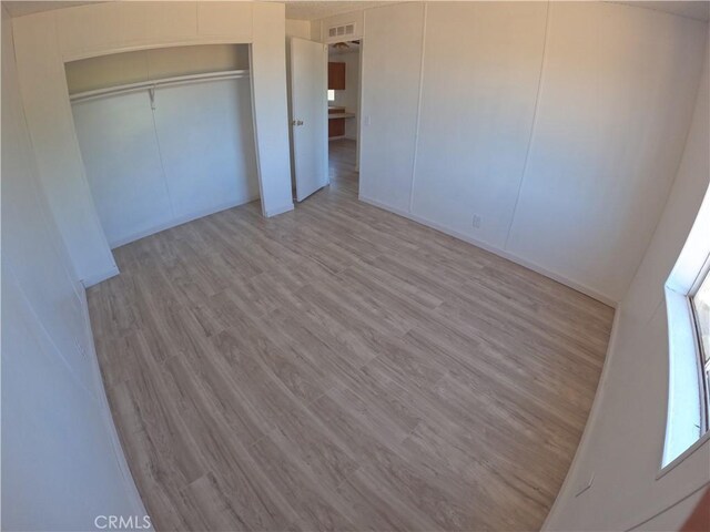 unfurnished bedroom featuring a closet and light wood-type flooring