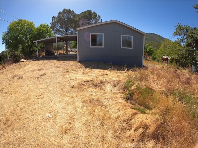 view of property exterior featuring a mountain view and a carport