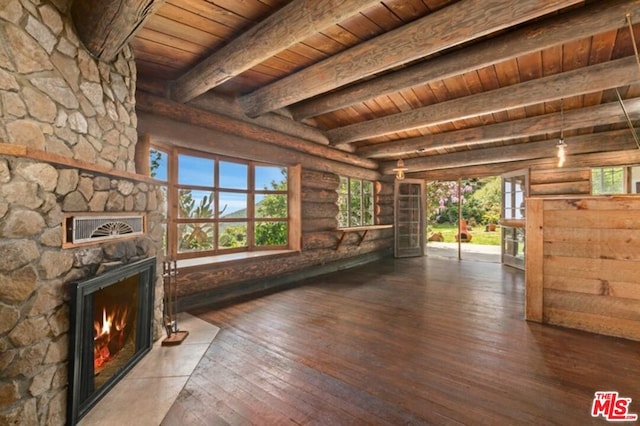 unfurnished living room with beam ceiling, log walls, wooden ceiling, dark wood-type flooring, and a healthy amount of sunlight