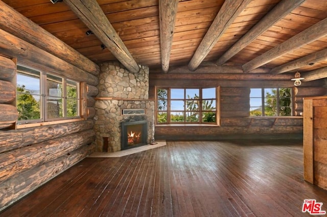 unfurnished living room featuring a stone fireplace, rustic walls, wooden ceiling, and dark wood-type flooring