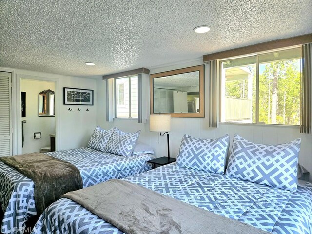 bedroom with a textured ceiling and connected bathroom