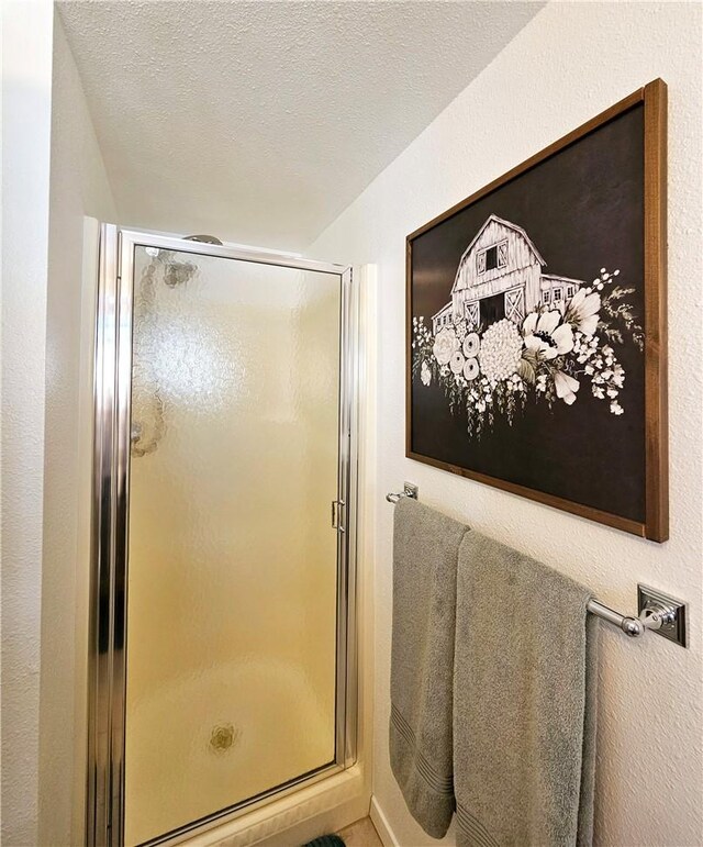 bathroom with walk in shower and a textured ceiling