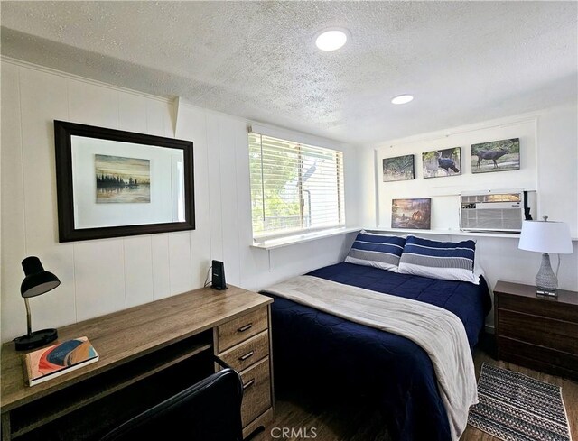 bedroom with hardwood / wood-style flooring, a textured ceiling, and cooling unit