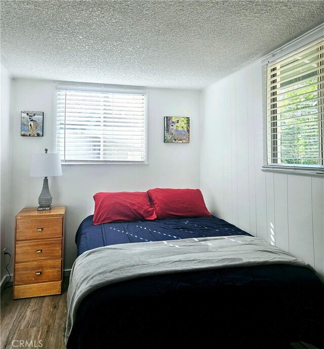 bedroom with dark wood-type flooring and a textured ceiling