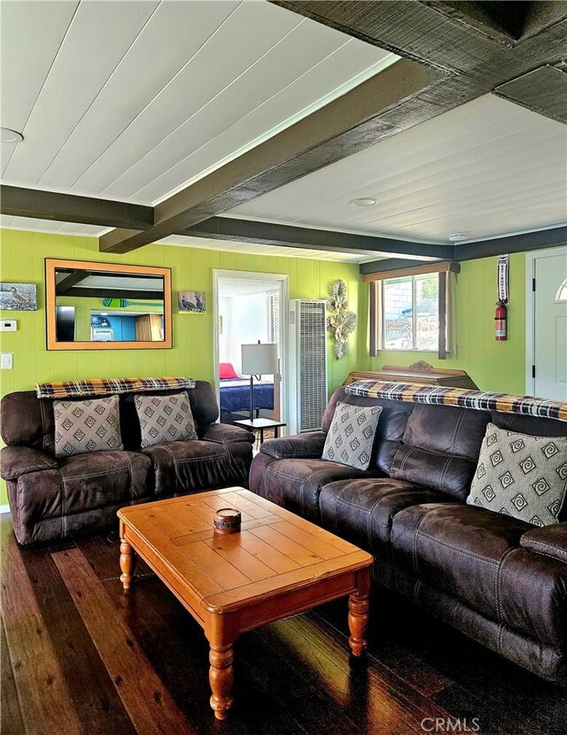 living room featuring beamed ceiling, wood walls, and hardwood / wood-style floors