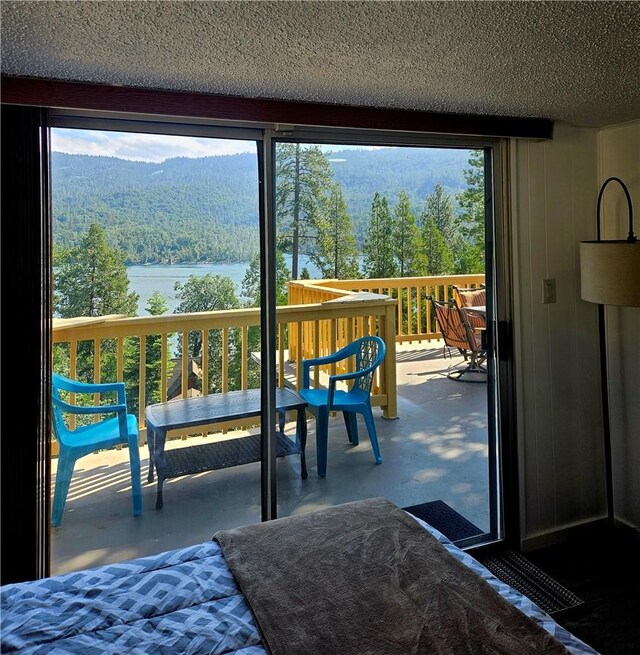 doorway featuring a water and mountain view and a textured ceiling