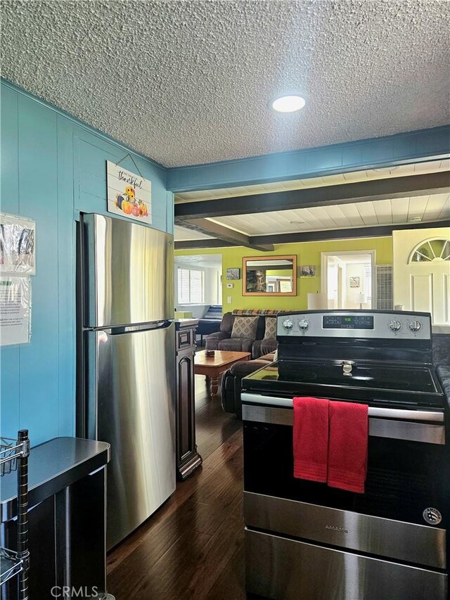 kitchen with a textured ceiling, dark wood-type flooring, and appliances with stainless steel finishes