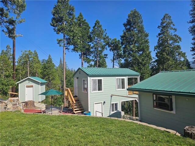 back of house featuring a storage unit and a yard