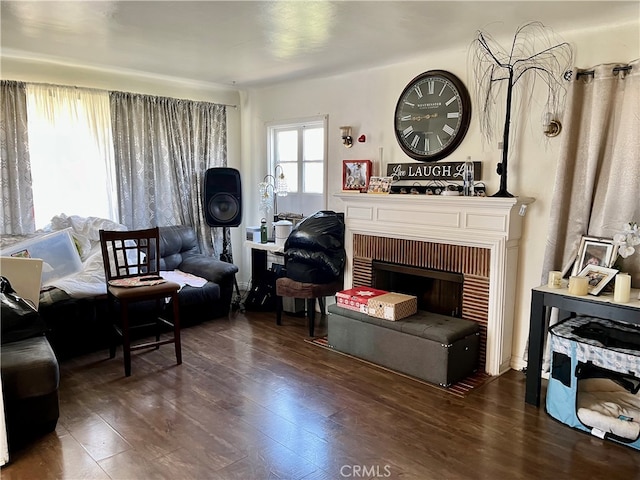 living room featuring dark hardwood / wood-style floors and a brick fireplace