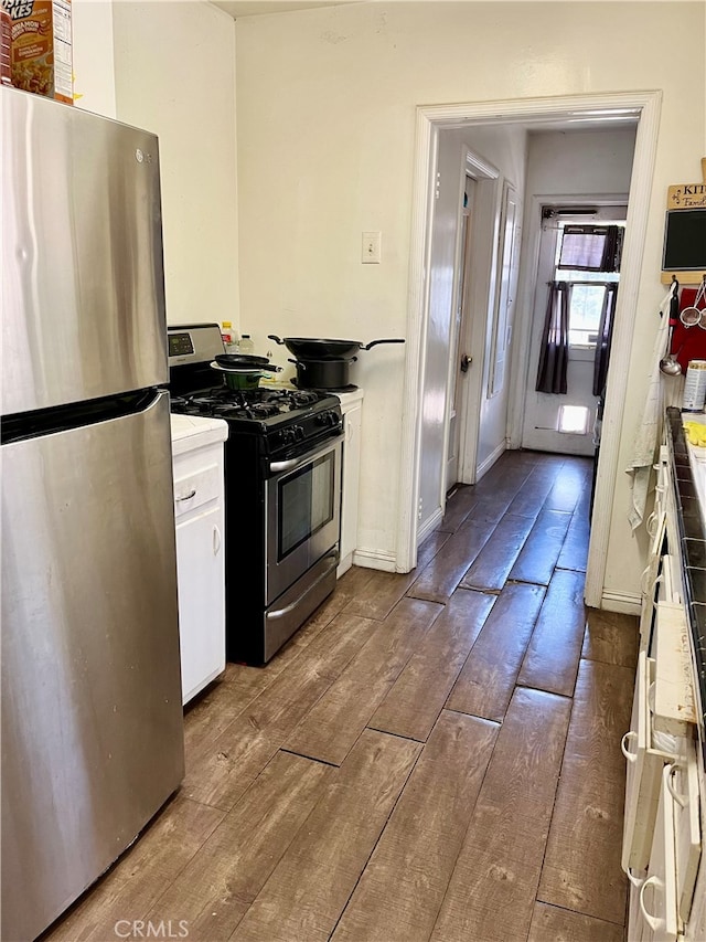 kitchen with stainless steel appliances, dark hardwood / wood-style floors, and white cabinets