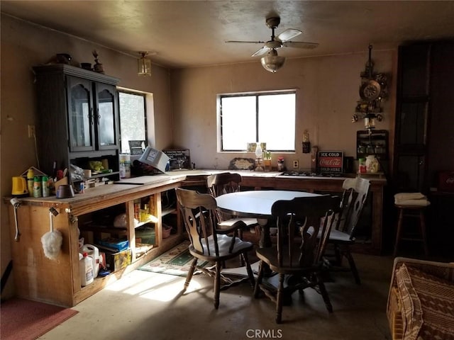 dining space featuring concrete floors and ceiling fan