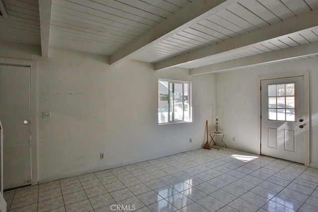 spare room featuring beam ceiling, light tile patterned floors, and wood ceiling