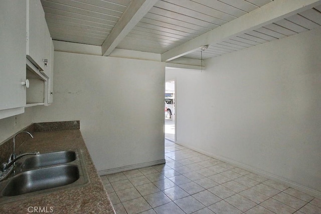 kitchen with sink, beamed ceiling, wood ceiling, and light tile patterned floors