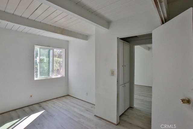 spare room featuring beamed ceiling, light hardwood / wood-style floors, and wood ceiling