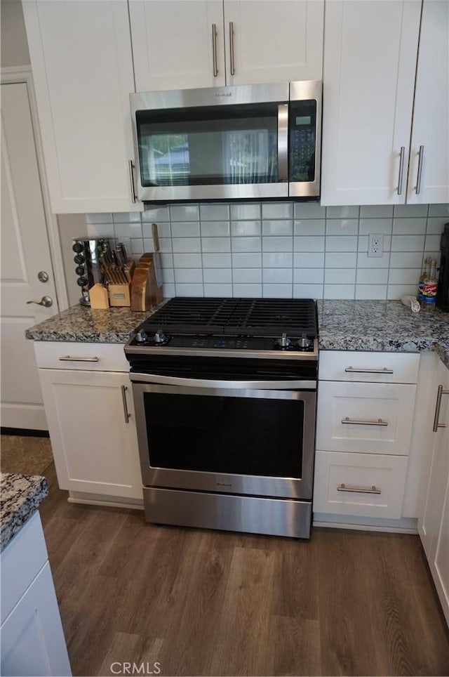 kitchen featuring light stone countertops, white cabinetry, and appliances with stainless steel finishes