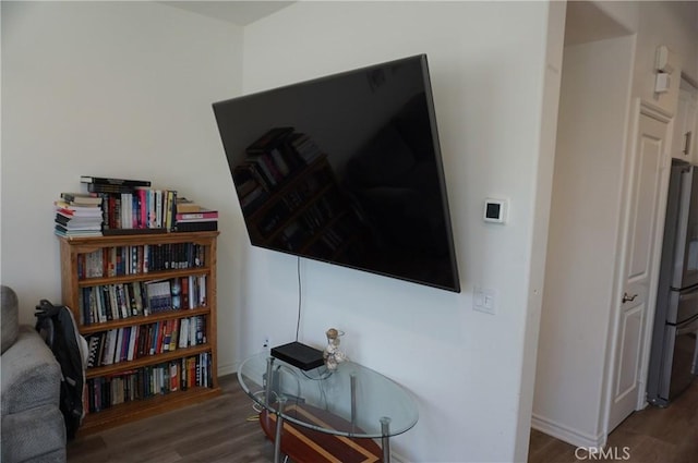 room details with stainless steel fridge and hardwood / wood-style flooring