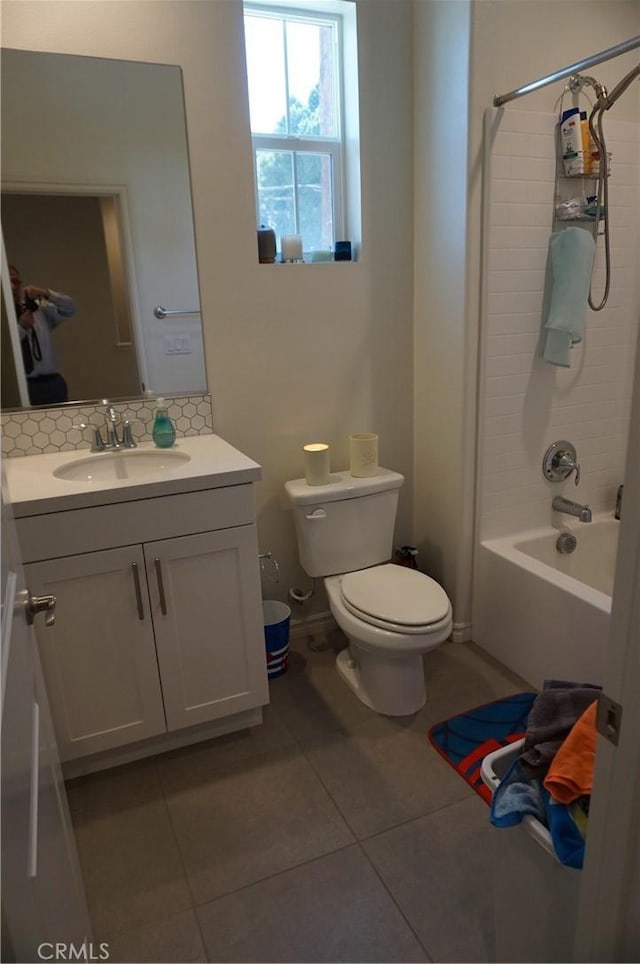 full bathroom with toilet, tasteful backsplash, vanity, tile patterned flooring, and washtub / shower combination