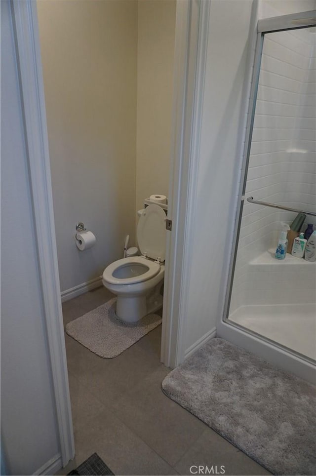 bathroom with walk in shower, tile patterned floors, and toilet