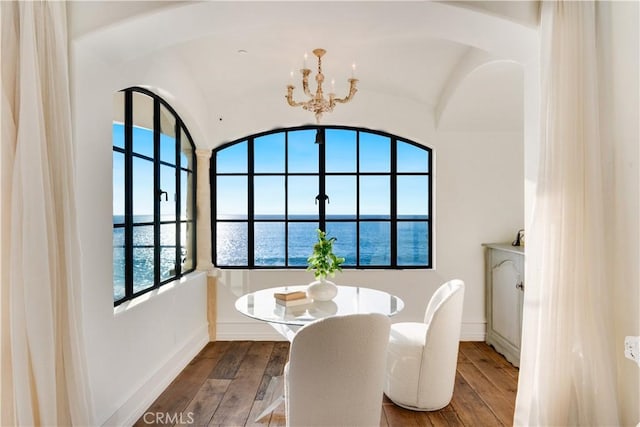 dining area featuring a chandelier, a water view, and wood-type flooring