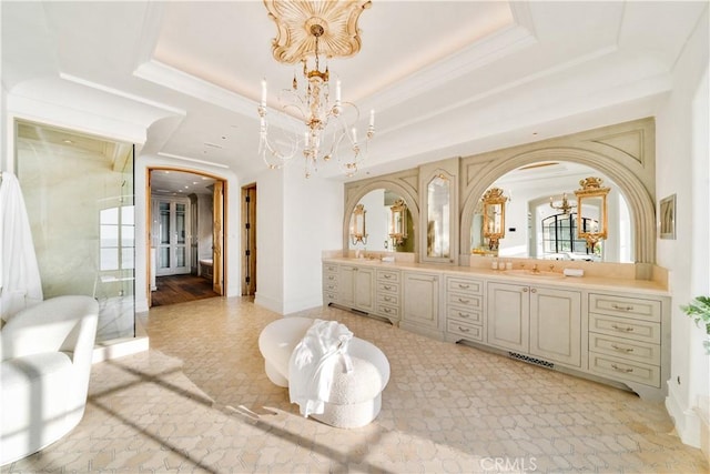 bathroom featuring ornamental molding, vanity, a raised ceiling, and a notable chandelier