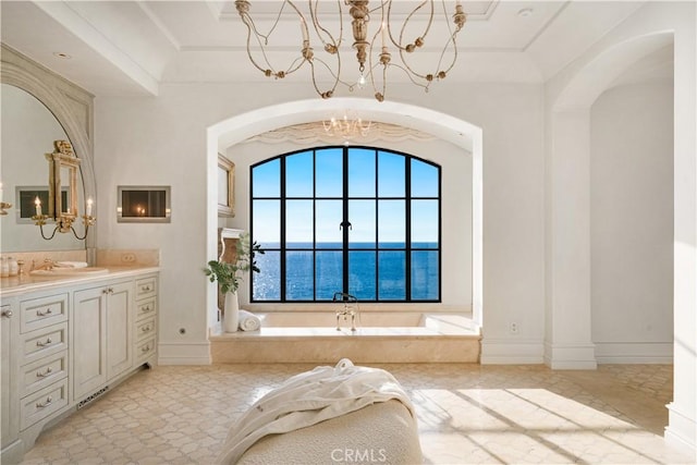 bathroom featuring a high end fireplace, a relaxing tiled tub, a water view, and vanity