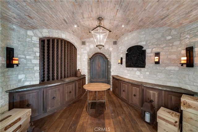 wine cellar with dark hardwood / wood-style flooring, lofted ceiling, and brick ceiling