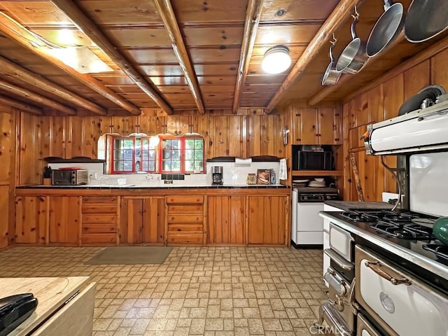 kitchen featuring white dishwasher, wood walls, and beam ceiling