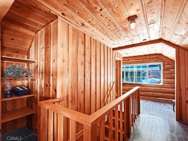 interior space featuring wood ceiling, dark wood-type flooring, wooden walls, and vaulted ceiling