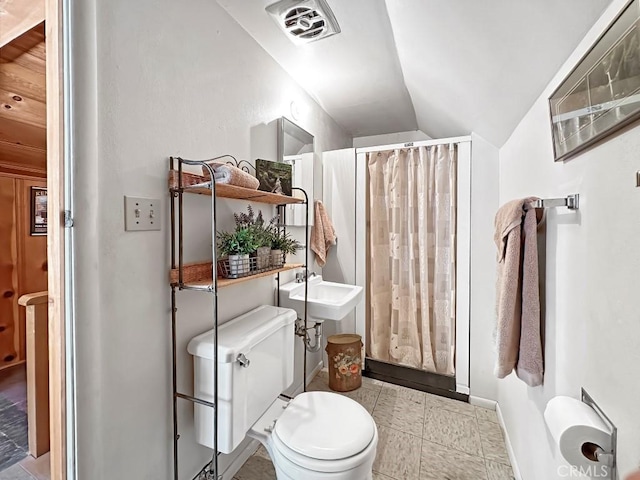 bathroom featuring a shower with shower curtain, lofted ceiling, and toilet