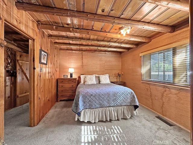 carpeted bedroom featuring beam ceiling, wood walls, and wood ceiling