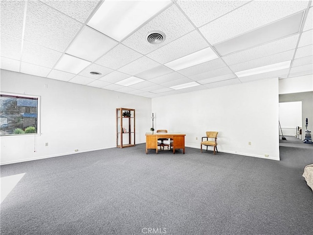 unfurnished room with a drop ceiling and dark carpet
