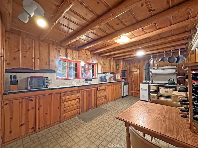 kitchen with wooden ceiling, beamed ceiling, white range oven, wood walls, and decorative backsplash