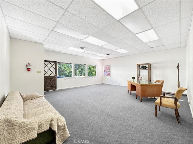 sitting room featuring a drop ceiling and carpet floors