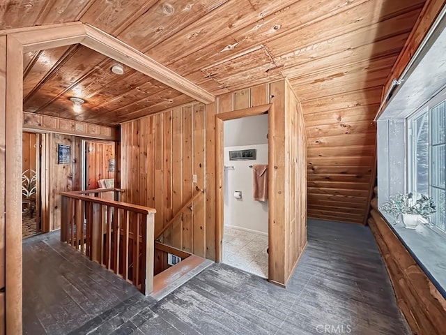 corridor featuring dark hardwood / wood-style floors, wooden ceiling, wooden walls, and lofted ceiling