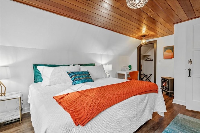 bedroom featuring lofted ceiling, wood-type flooring, wooden ceiling, and a wood stove