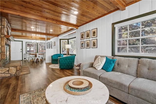 living room featuring a healthy amount of sunlight, dark wood-type flooring, wooden ceiling, and beamed ceiling