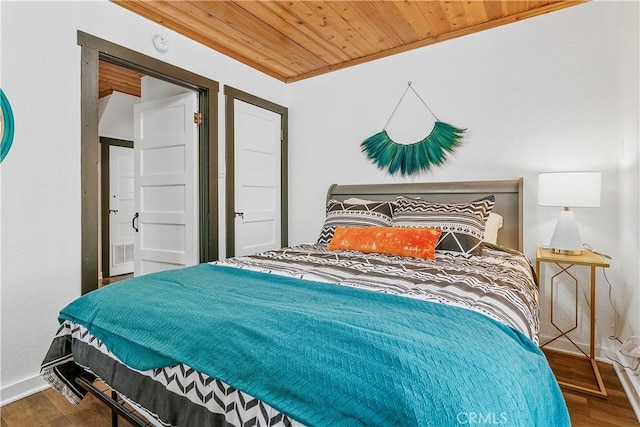 bedroom featuring crown molding, hardwood / wood-style floors, and wooden ceiling