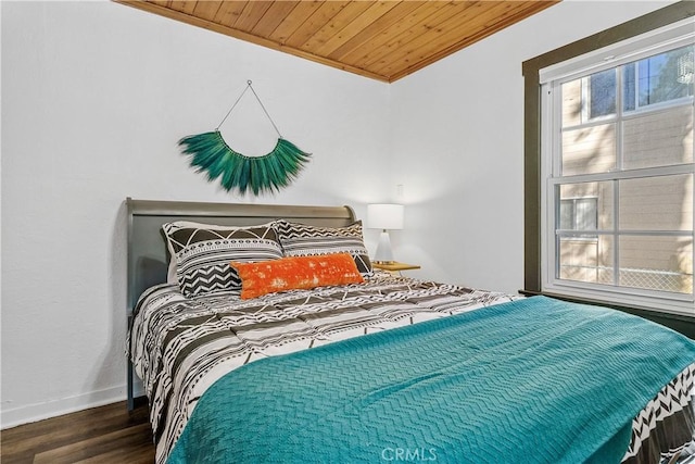 bedroom featuring ornamental molding, dark hardwood / wood-style floors, and wooden ceiling