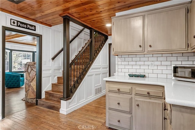 kitchen featuring cream cabinets, light hardwood / wood-style floors, and wooden ceiling