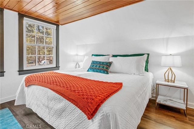 bedroom with lofted ceiling, dark wood-type flooring, and wooden ceiling