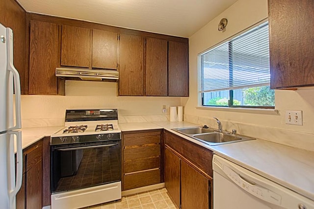 kitchen featuring sink, white appliances, and light tile floors