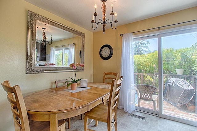 dining room with a chandelier and light tile floors