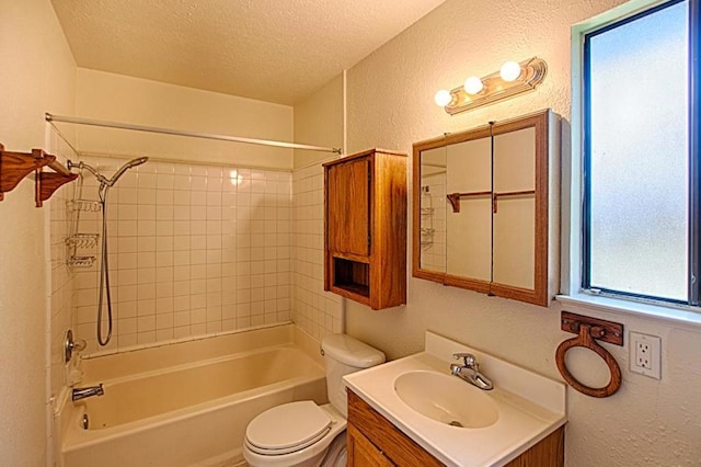 full bathroom featuring toilet, a textured ceiling, vanity, and tiled shower / bath