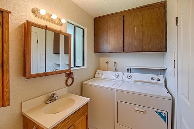 laundry room featuring washing machine and clothes dryer, a textured ceiling, a wealth of natural light, and sink