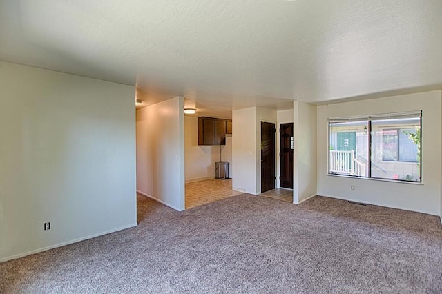 interior space featuring light carpet and a textured ceiling