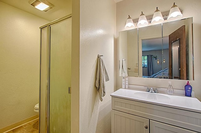 bathroom featuring toilet, tile flooring, and vanity