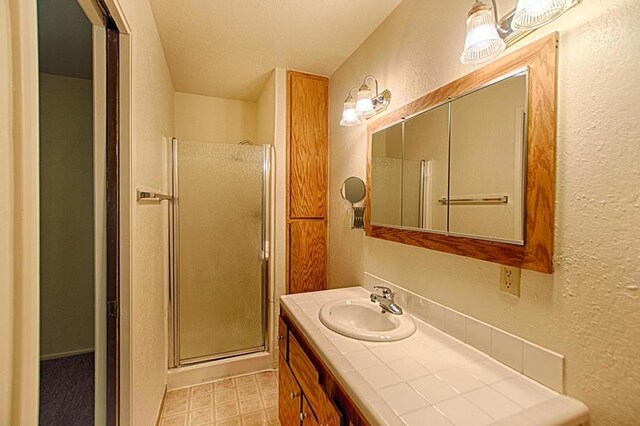 bathroom featuring tile floors, vanity, and a shower with door