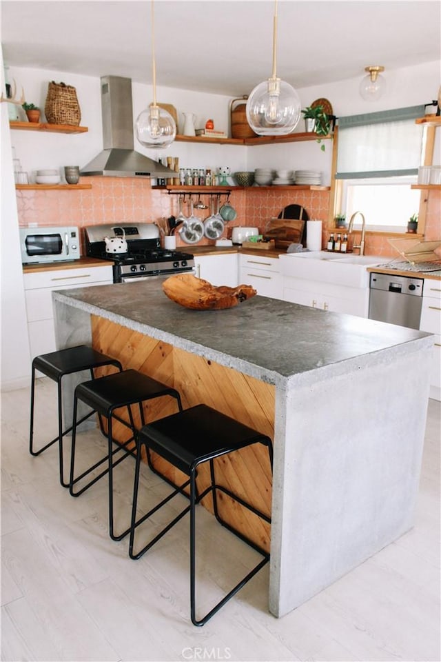 kitchen with white cabinetry, a breakfast bar area, and exhaust hood