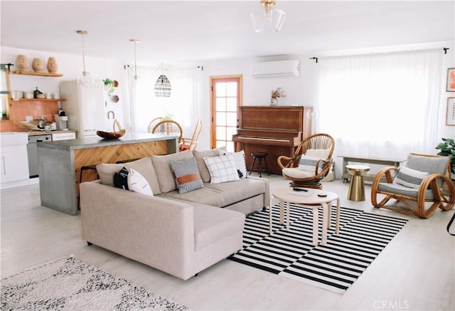 living room featuring light hardwood / wood-style floors and a wall unit AC