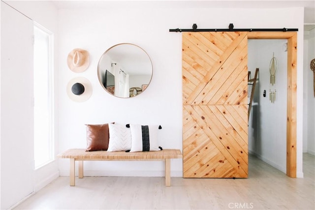 mudroom featuring a barn door and wood-type flooring